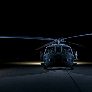 A UH-60 Black Hawk helicopter lit up by multiple external flash units