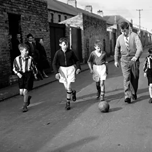 Bobby Charlton plays football with children in his home town of Ashington