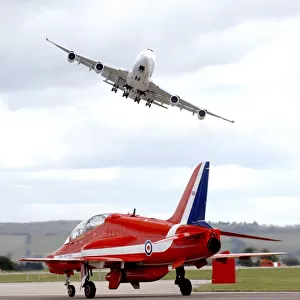 On Boeing 747 Swoops Over a Royal Air Force Red Arrow at Air Show