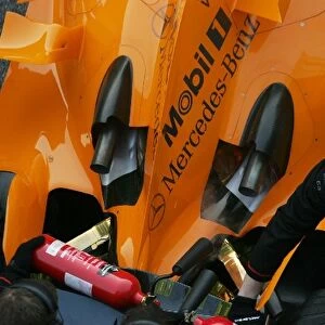 Formula One Testing: McLaren mechanics have to use fire extinguishers on the exhausts of Kimi Raikkonen McLaren Mercedes MP4 / 21