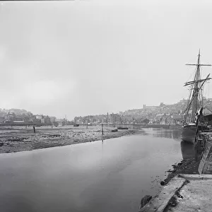 negative 1900, Victorian era. River Esk at Whitby with sailing ship moored in harbour looking into the town