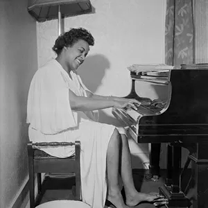 Winifred Atwell, pianist, seen here rehearsing after warming up both her hands and feet