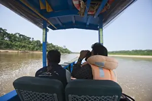 : Birdwatching from a motorised canoe along the Tambopata River in the Peruvian Amazon