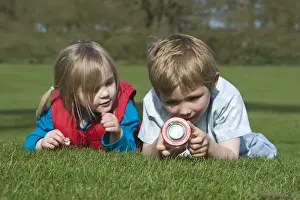 Wildlife Prints: Children looking at ladybirds in bug collecting jar Norfolk spring