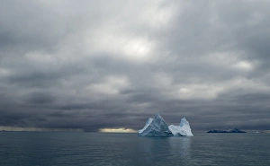 Iceberg and in distance Annekov Island off the rarely visited south west coast of Iceberg and in distance Annekov Island off the rarely visited south west coast of