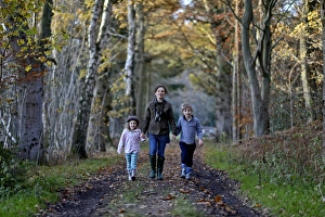 Mother, son and daughter on woodland walk in autumn Norfolk