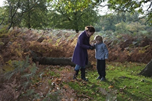 Mother and son in woodland in autumn Kent UK