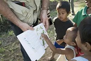 Palawan Prints: Tim Appleton showing local boys bird illustrations in a field guide at Narra on Palawan