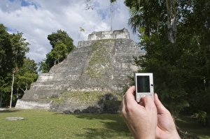 Tourist using a digital camera to photograph a Mayan temple at Yaxha nr Tikal Guatemala Tourist using a digital camera to photograph a Mayan temple at Yaxha nr Tikal Guatemala