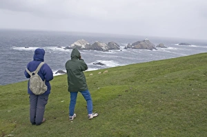 Walkers looking out on Britains most northerly point Muckle Flugga off Hermaness Walkers looking out on Britains most northerly point Muckle Flugga off Hermaness
