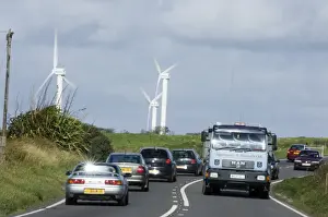 Road Prints: Wind turbines and cars along road near Goonhilly Down Cornwall summer
