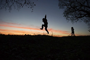 Young boy and girl playing at dusk on edge of woodland Norfolk winter Young boy and girl playing at dusk on edge of woodland Norfolk winter