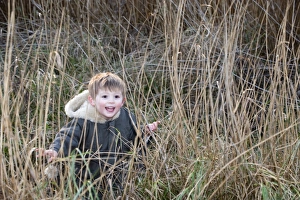 Exploring Prints: young boy playing hide and seek in reeds Norfolk winter